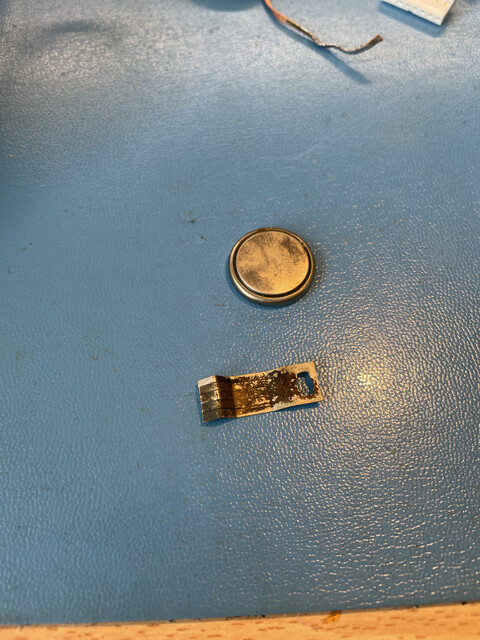 The old and crusty battery, with a crusty tab.